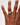 Hand wearing a ring on a plain background