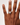 Hand wearing a ring on a plain background