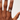 Hand wearing a ring on a plain background