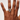 Hand wearing a ring with a visible brand logo on a plain background