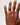 Hand wearing a gold ring on a plain background