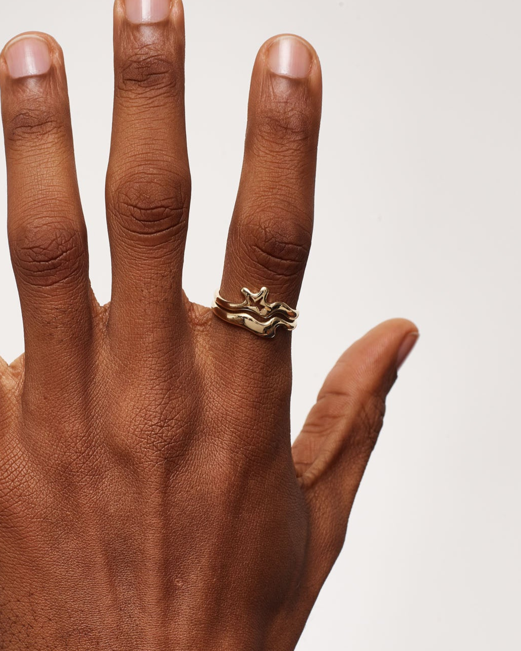 Hand with a ring on a plain background
