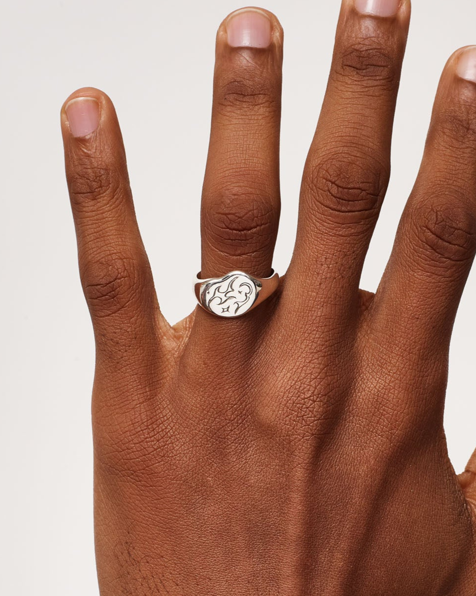 Hand wearing a ring on a plain background