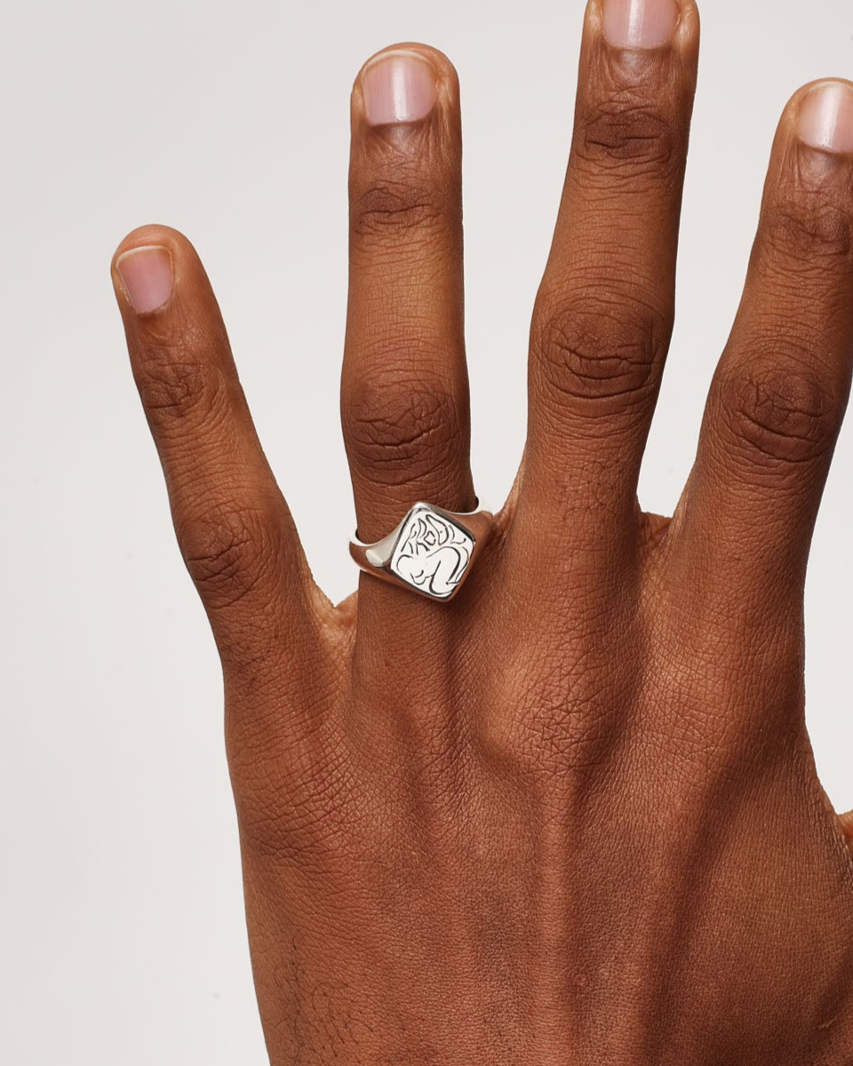 Hand wearing a diamond ring on a plain background