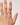 Hand wearing a ring on a plain background
