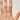 Hand wearing a gold ring with a gemstone on a plain background