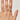 Hand wearing a gold ring with a blue stone on a plain background